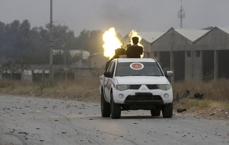 Fighters drive past the spot where a mortar had just hit during clashes. AFP