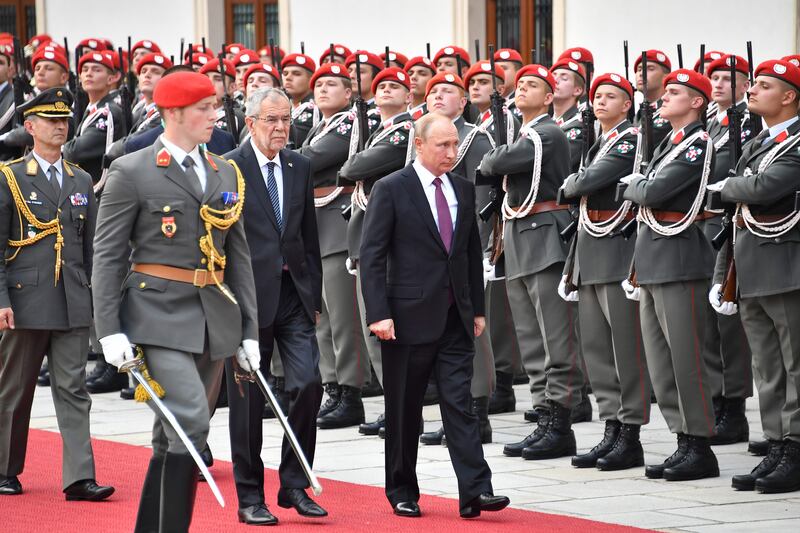 Austria's President Alexander van der Bellen (C) and Russian President Vladimir Putin (R) inspect a military honor guard at the Presidential palace in Vienna, Austria, on June 5, 2018.  / AFP / JOE KLAMAR
