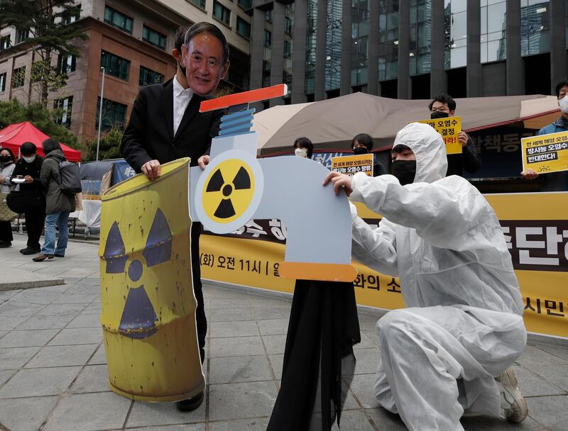 An environmental activist wearing a mask of Japanese Prime Minister Yoshihide Suga performs to denounce the Japanese government's decision on Fukushima water, near the Japanese embassy in Seoul. AP