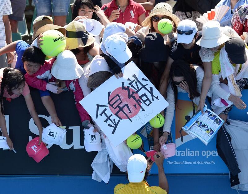 Japan's Kei Nishikori signs autographs for supporters after victory in his men's singles match against Marinko Matosevic of Australia. Mal Fairclough / AFP