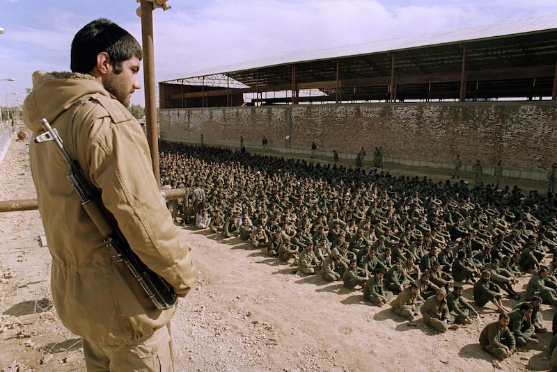 An Iranian soldier guards Iraqi prisoners of war in Ahvaz, Iran, on January 22, 1987. AFP