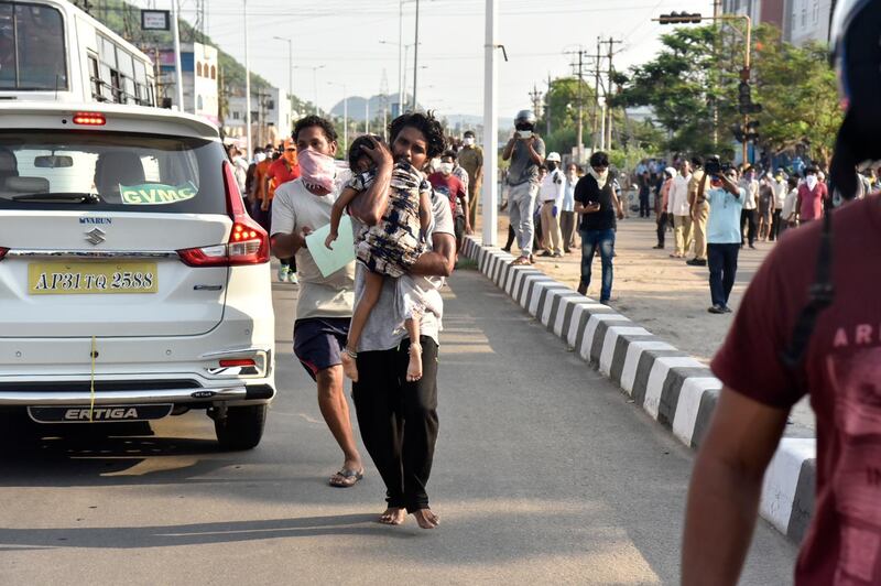 A man runs carrying a child affected by a chemical gas leak in Visakhapatnam, India. AP Photo