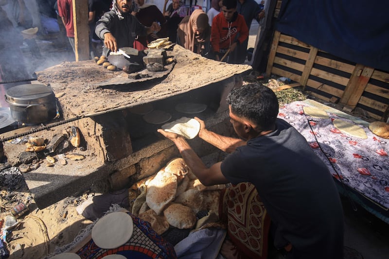 Palestinians bake bread over a fire due to the lack of cooking gas at a camp in Khan Younis, Gaza, where basic supplies are running out. Bloomberg