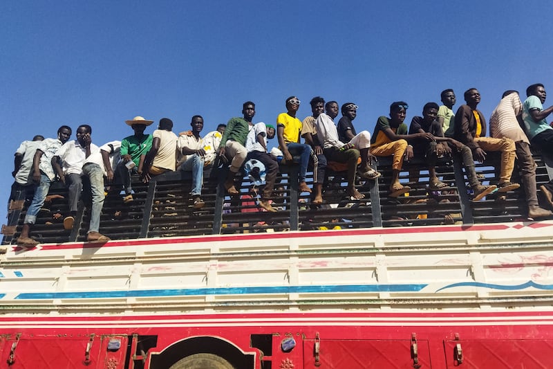 Displaced Sudanese ride on top of a lorry in Wad Madani on December 16. AFP