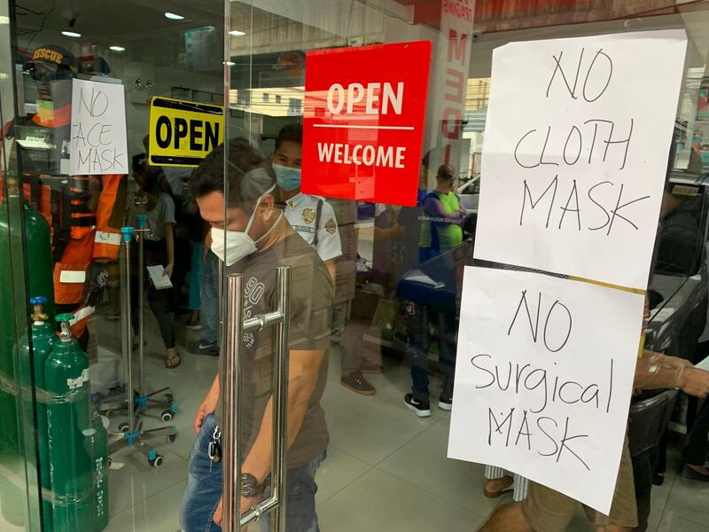 A man wearing a mask walks out of a medical equipment store in Manila, Philippines.  EPA