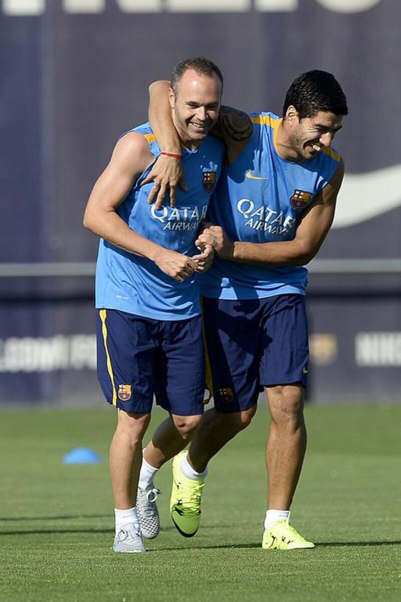 Luis Suarez, right, and Andres Iniesta share a joke during training. Josep Lago / AFP / July 13, 2015