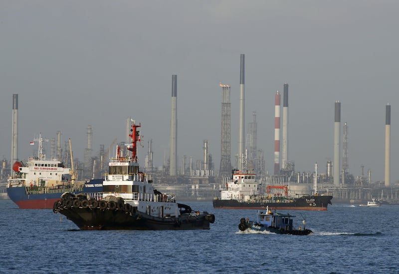 FILE PHOTO: Vessels pass an oil refinery in the waters off the southern coast of Singapore, February 26, 2016. REUTERS/Edgar Su/File Photo