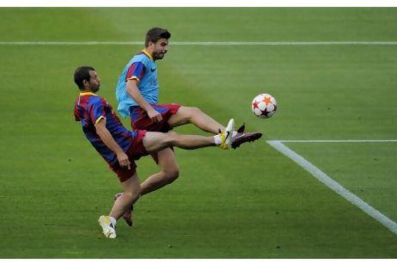 Javier Mascherano, left, and Gerard Pique battle for the ball during Barcelona's final training session at Camp Nou before they left for London last night. The two could be paired together in the heart of the defence for Saturday's Champions League final against Manchester United at Wembley Stadium.
