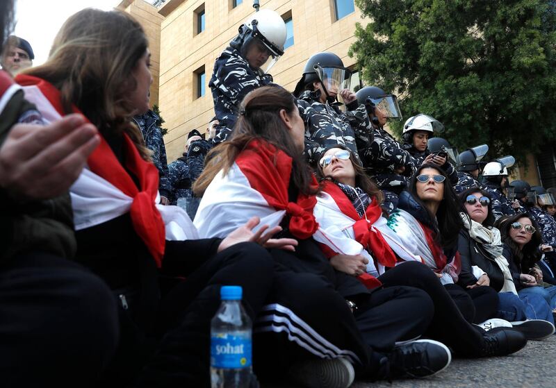 Anti-government protesters block a road to prevent the Lebanese lawmakers from reaching the parliament building to attend the 2020 budget discussion. AP