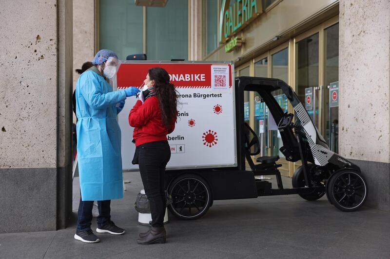 A medical assistant takes a swab sample for a Covid-19 test from a woman at a "Coronabike" mobile testing station in Berlin, Germany. Getty Images