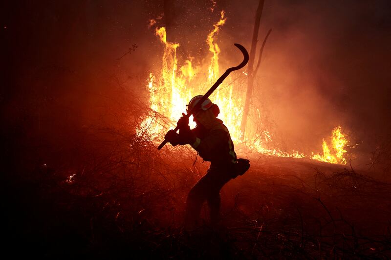 A firefighter tackles a forest blaze during an outbreak of wildfires in Peidrafita, Asturias, Spain. Reuters