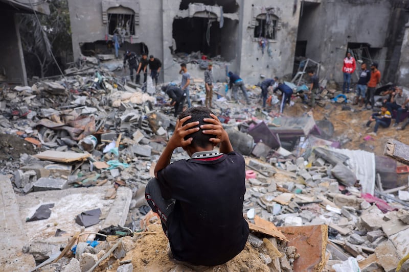 People salvage belongings from a damaged building following strikes on Rafah. AFP