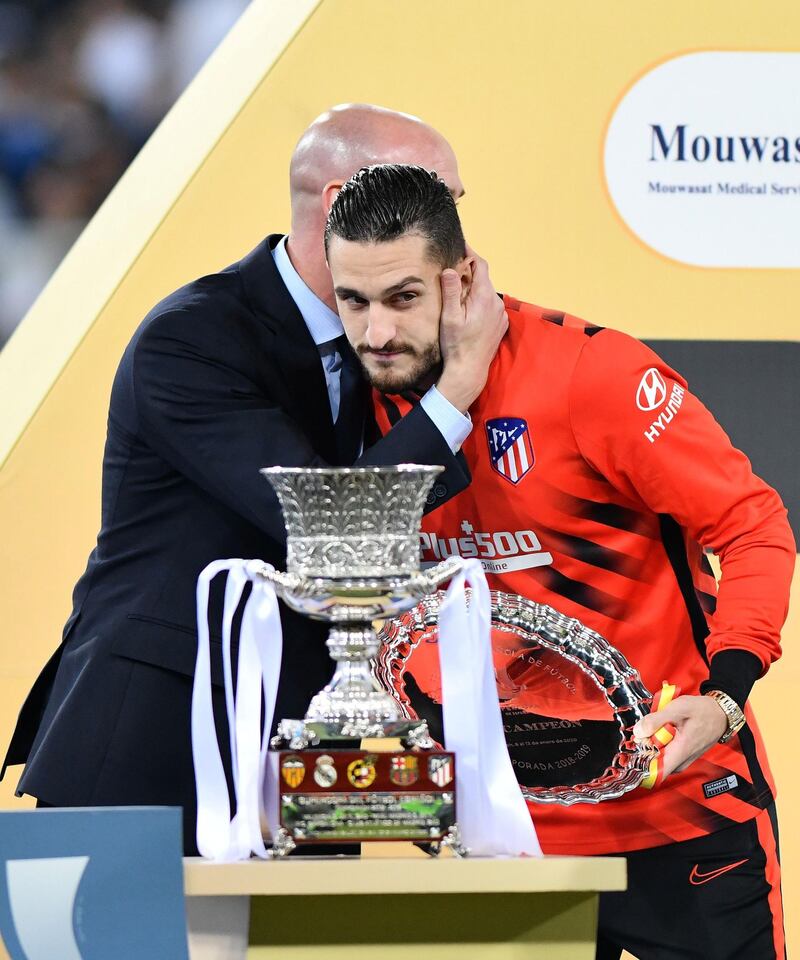 Atletico Madrid's Koke looks dejected as he poses in front of the trophy. Reuters