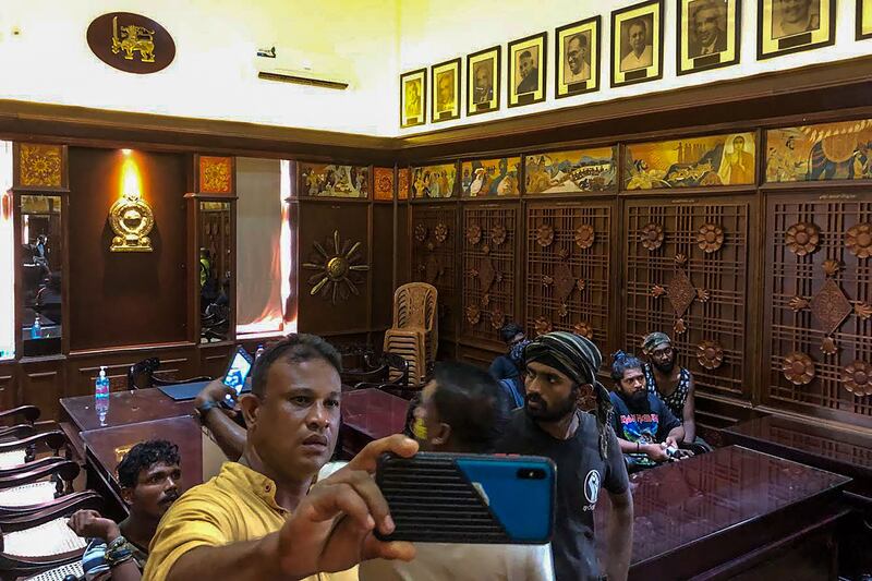 Demonstrators takes pictures inside the complex housing the Sri Lankan prime minister's offices. AFP