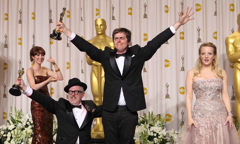 ** EMBARGOED AT THE REQUEST OF THE ACADEMY OF MOTION PICTURE ARTS & SCIENCES FOR USE UPON CONCLUSION OF THE ACADEMY AWARDS TELECAST **Brandon Oldenburg, second from left, and William Joyce, second from right, pose with presenters Ellie Kemper, left, and Wendi McLendon-Covey as they jump with their awards for best animated short film for "The Fantastic Flying Books of Mr. Morris Lessmore" during the 84th Academy Awards on Sunday, Feb. 26, 2012, in the Hollywood section of Los Angeles. (AP Photo/Joel Ryan) *** Local Caption ***  84th Academy Awards Press Room.JPEG-0c4a4.jpg