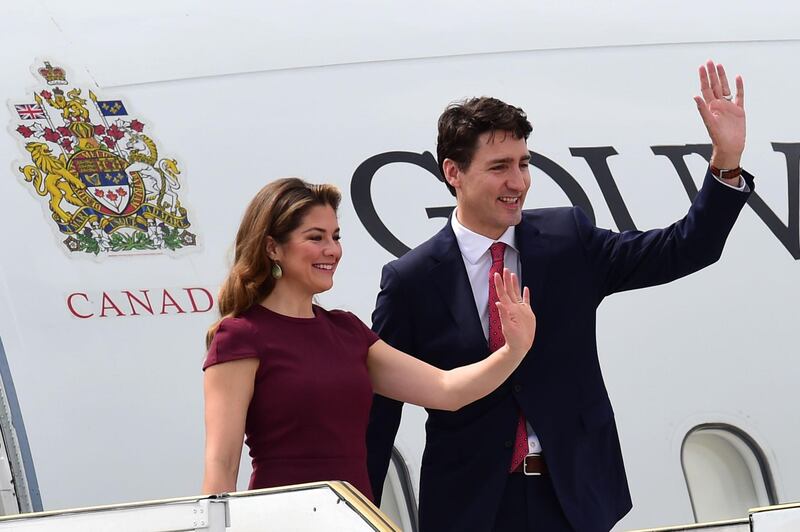 Canada's Prime Minister Justin Trudeau (R) and his wife Sophie Gregoire, wave upon arrival at Ezeiza International airport in Buenos Aires province, on November 29, 2018. Global leaders gather in the Argentine capital for a two-day G20 summit beginning on Friday likely to be dominated by simmering international tensions over trade. / AFP / Martin BERNETTI                     
