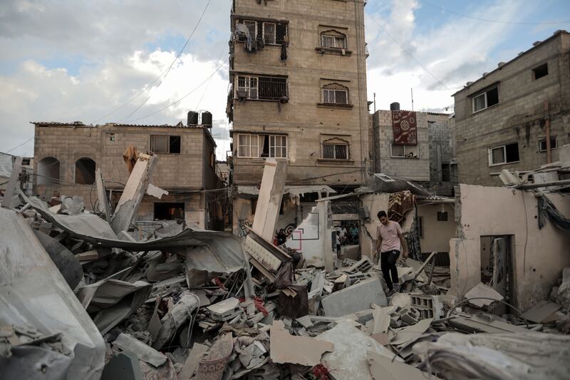 People search through buildings destroyed during Israeli air strikes in the southern Gaza Strip on November 14. Getty Images
