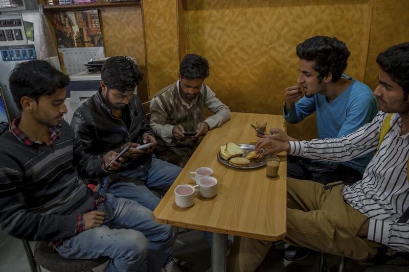 Kashmiri students browse on their smartphones in a cafe in Srinagar. Dar Yasin / AP Photo