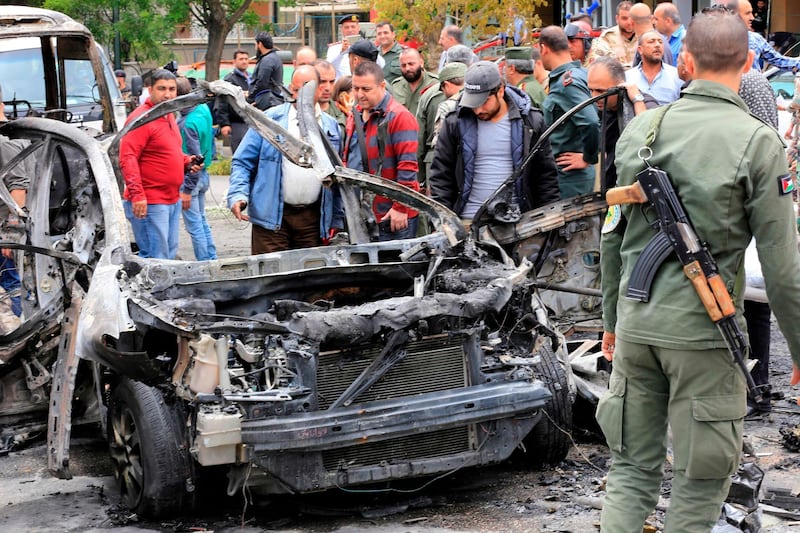 Syrians surround a charred car following an explosion in Damascus on May 9, 2018. 
A shelling and a car bomb blast in Syria's capital Damascus killed two people and wounded several others today, state television said. It reported "two killed and 14 wounded in terrorist attacks on Damascus Tower and Maysat Square". The shell struck at the tower in the central Marjeh Square district while the car bomb went off in the northeast of the city. 
 / AFP PHOTO / LOUAI BESHARA