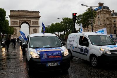 'Police is not racist' is written on a vehicle as members of French police unions including Alliance Police nationale, drive past the Arc de Triomphe on the Champs-Elyses Avenue, on June 12, 2020 in Paris, during a protest against the French Interior Minister's latests announcements following demonstrations against racism and police violence. Interior Minister banned police from using chokeholds to detain suspects and has promised "zero tolerance" for racism in law enforcement. He has acknowledged that too many officers "have failed in their Republican duty" in recent weeks, with several instances of racist and discriminatory remarks revealed. / AFP / Thomas SAMSON

