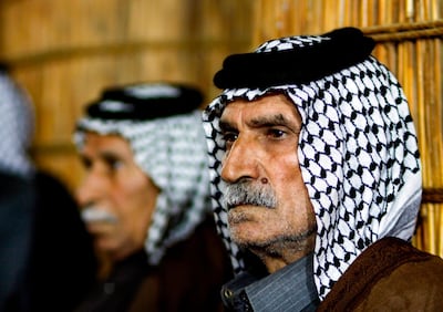 Members of an Iraqi clan gather inside a straw tent in the town of Mishkhab, south of Najaf on November 15, 2018. For centuries, Iraqi clans have used their own system to resolve disputes, with tribal dignitaries bringing together opposing sides to mediate in de facto "hearings" and if one side failed to attend the rival clan would fire on the absentee's home their fellow tribesmen's, a practice known as the "degga ashairiya" or "tribal warning". 
Authorities however are currently classifying it as a "terrorist act" punishable by death. / AFP / Haidar HAMDANI
