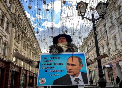 TOPSHOT - An activist distributes election leaflets in support of presidential candidate, President Vladimir Putin on a street in downtown Moscow on March 16, 2018.
Russia will vote for president on March 18, 2018. / AFP PHOTO / Yuri KADOBNOV