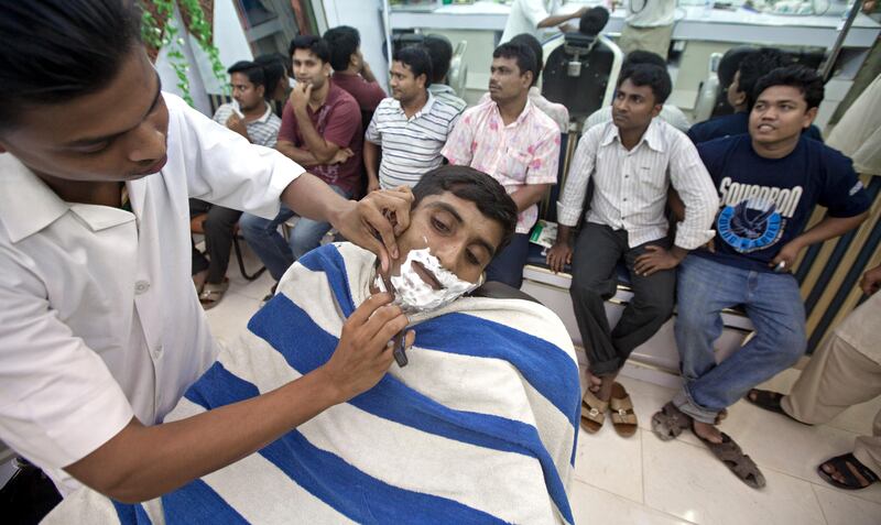 Ajman, August 8, 2011 - Lincoln Shil moved from Bangladesh four months ago. Now he cuts hair and shave gentleman in the Al Rehab Hair Cutting Saloon in the Al Nakeel neighborhood near the Gold Souk in Ajman City, Ajman August 8, 2011. (Jeff Topping/The National) 