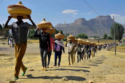 Ethiopian men carry traditional hand-woven food baskets on their heads as they walk ceremoniusly to a reconciliation meeting in the Irob district in northern Ethiopia near the border with Eritrea, near Adigrat, on October 23, 2019. Residents of Ethiopia's northernmost villages complain that there has been no progress on demarcating the two countries' 1,000-kilometre shared border. 
These problems touch nearly everyone living in cities and towns nestled among the steep escarpments of Ethiopia's northern Tigray region -- the area most affected by the 1998-2000 border war and the long, bitter stalemate that followed.  / AFP / MICHAEL TEWELDE
