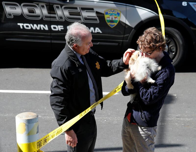 Chief of Burlingame police Eric Wollman reunites a YouTube employee with his dog, Kimba, after he was left at the scene following the shooting. EPA/JOHN G. MABANGLO