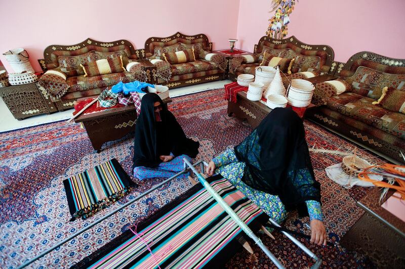 Madinat Zayed, January 21, 2013 -- (L to R) Shamsa Almazrouei, 80, watches as her daughter Hamda Almazrouei, 46, uses a floor loom to weave a table runner at their home in Madinat Zayed, January 21, 2013. (Photo by: Sarah Dea/The National)