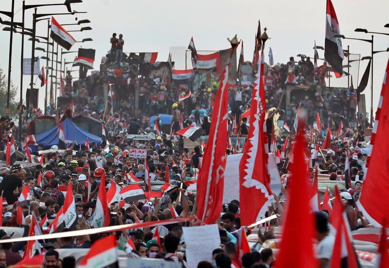 Anti-government protesters stand on barriers set up by Iraqi security to close the Joumhouriya bridge leading to the Green Zone government areas in Baghdad. AP Photo