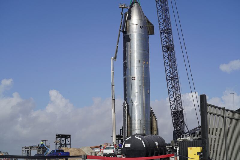 Workers prepare to move a Starship rocket. 