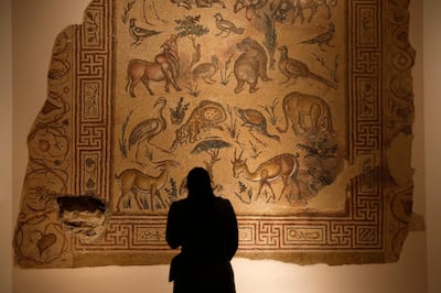 In this Jan. 28, 2016, photo, a visitor checks the mosaic of the Good Shepherd that was badly damaged in the lower left corner by a sniper during the 1975-1990 Lebanese civil war at the Lebanese National Museum in Beirut, Lebanon. Nearly 30 years after civil war guns fell silent, dozens of bullet-scarred, shell-pocked buildings are still standing _ testimony to a brutal conflict that raged for 15 years and took the lives of 150,000 people.(AP Photo/Hassan Ammar)