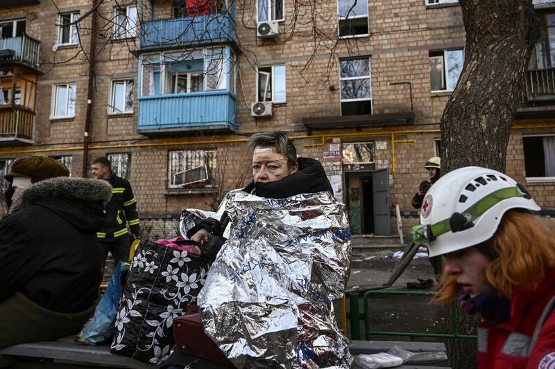 An injured woman looks on as she receives medical treatment after shelling in a residential area in Kyiv on Friday. (Photo by Aris Messinis  /  AFP)