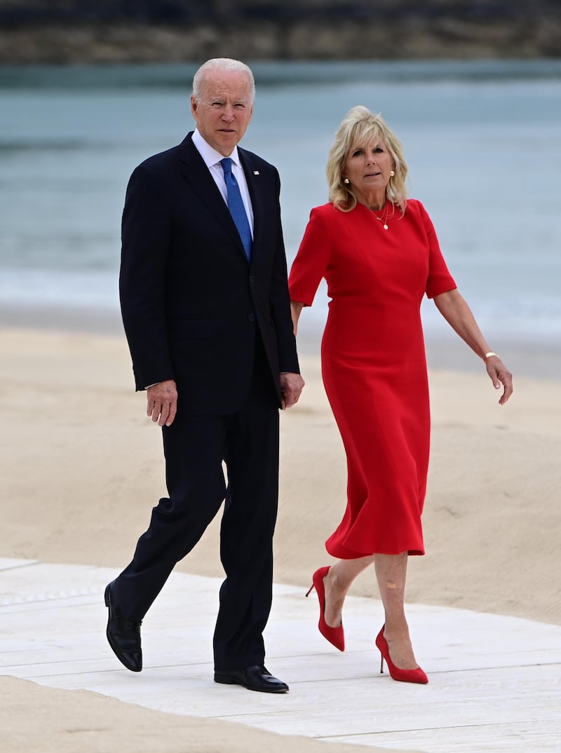 President Joe Biden and Jill Biden, in a red dress and shoes, arrive at the leaders' welcome during the G7 Summit in Cornwall on June 11, 2021. EPA