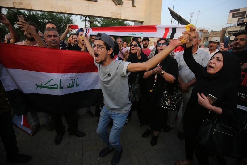 Iraqi protesters wave national flags and chant slogans during a demonstration against corruption and lack of services in Tahrir Square in central Baghdad. AFP