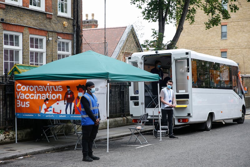 A vaccination bus operates outside Park Walk Primary School in London.