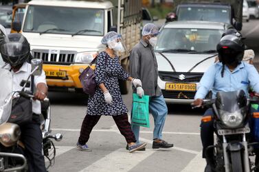 People wear mask to get protected from the coronavirus in Bangalore, India. Capital flows to emerging markets securities fell 48 per cent in July, according to the Institute of International Finance report. EPA/JAGADEESH NV