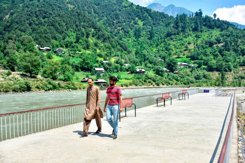 Kashmiris walk at a tourist place alongside a river near the Line of Control, the de facto border between Pakistan and India, in Neelum Valley of Pakistan-administered Kashmir. AFP