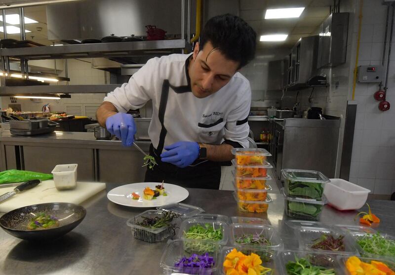 Chef Bassem Bizid arranges leaf vegetables and edible flowers for a dish at a luxury hotel in Gammarth, Tunisia. AFP