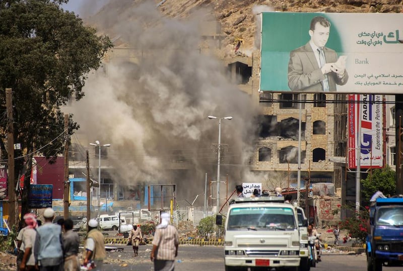 Smoke billows after a mortar shell hit a building in the Beer Basha area in Teaz on March 12, 2016. Ahmad Al Basha / AFP

