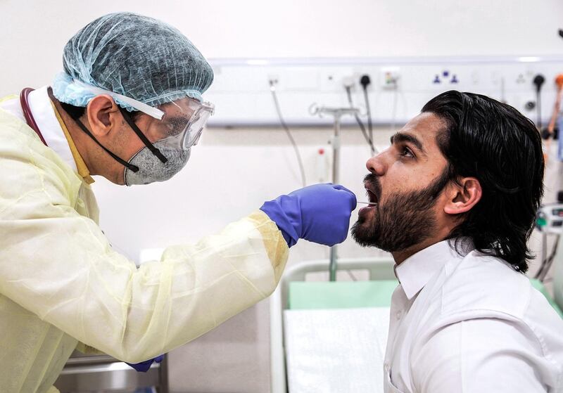 Abu Dhabi, United Arab Emirates, March 18, 2020.  
   Dr. Faisal inserts a swab in the mouth of a patient for a coronavirus test at the Burjeel Hospital, Abu Dhabi.
Victor Besa / The National
Reporter:  Ramola Talwar
Section:  NA