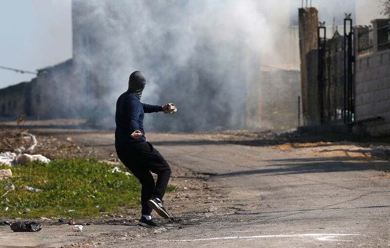 A Palestinian protester throws stones at Israeli troops after a demonstration against Israeli settlements in Kafr Qaddum village, near Nablus. EPA.