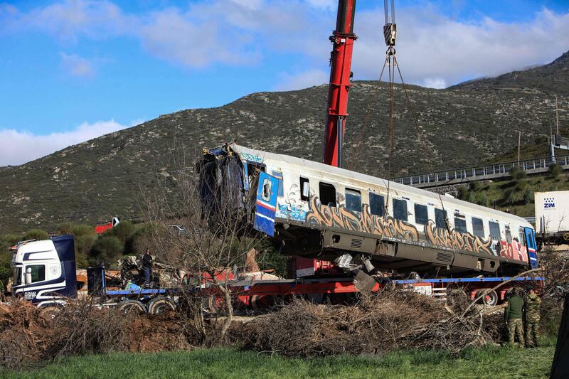 A damaged carriage is removed from the scene after a head-on collision between two trains near Larissa, Greece, on February 28. AFP 
