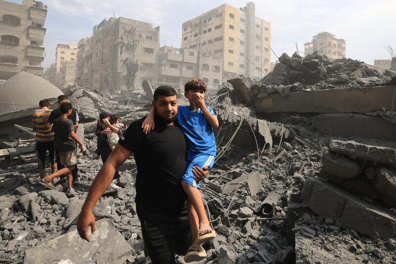 Palestinians evacuate the area following an Israeli airstrike on the Sousi mosque in Gaza city on Monday. AFP