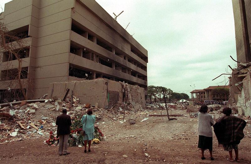 This August 1998 file picture shows Kenyan residents looking at the US embassy (L) days after the bomb blast that killed at least 280 kenyans and 12 american 07 August 1998. The jury in New York has begun deliberation in the bombings in Nairobi and Dar es Salaam and the verdict is expected in the next days. AFP PHOTO/FILES/ALEXANDER JOE (Photo by ALEXANDER JOE / AFP FILES / AFP)