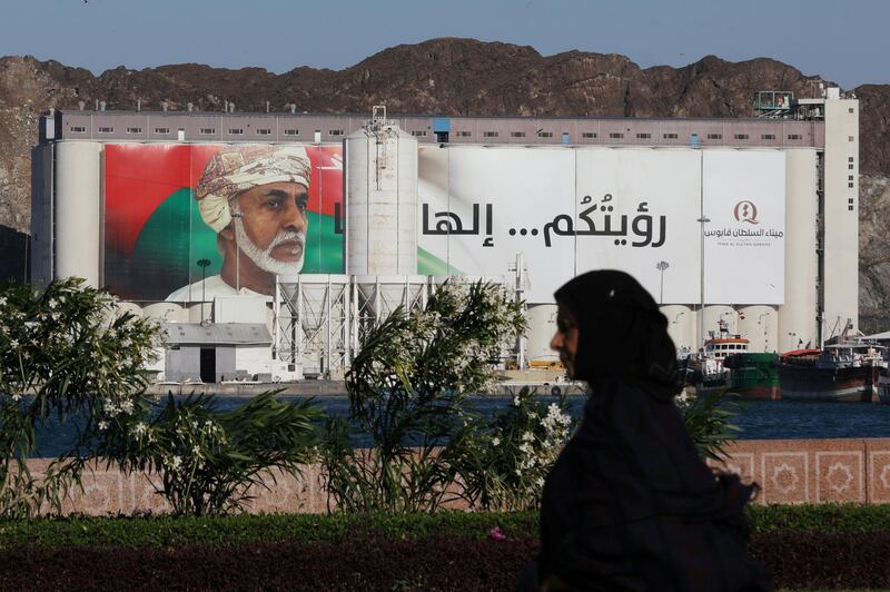 A woman walks past a portrait of Oman's Sultan Qaboos bin Said on a building in Muscat, Oman. Reuters