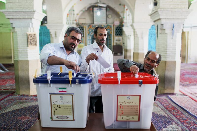Iranian men cast their ballots during presidential elections at a polling station in Qom, 125 kilometers (78 miles) south of the capital Tehran, Iran, Friday, June 14, 2013. (AP Photo/Ebrahim Noroozi) *** Local Caption ***  APTOPIX Mideast Iran Election.JPEG-0cc73.jpg