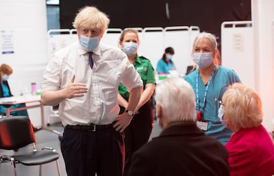 Britain's Prime Minister Boris Johnson speaks to patients and staff at a mass vaccination centre at Ashton Gate stadium in Bristol, southwest England on January 11, 2021.  Seven mass coronavirus vaccination sites opened across England on Monday as the government races to dose millions of people while a new strain of the disease runs rampant across the country.  / AFP / POOL / Eddie MULHOLLAND

