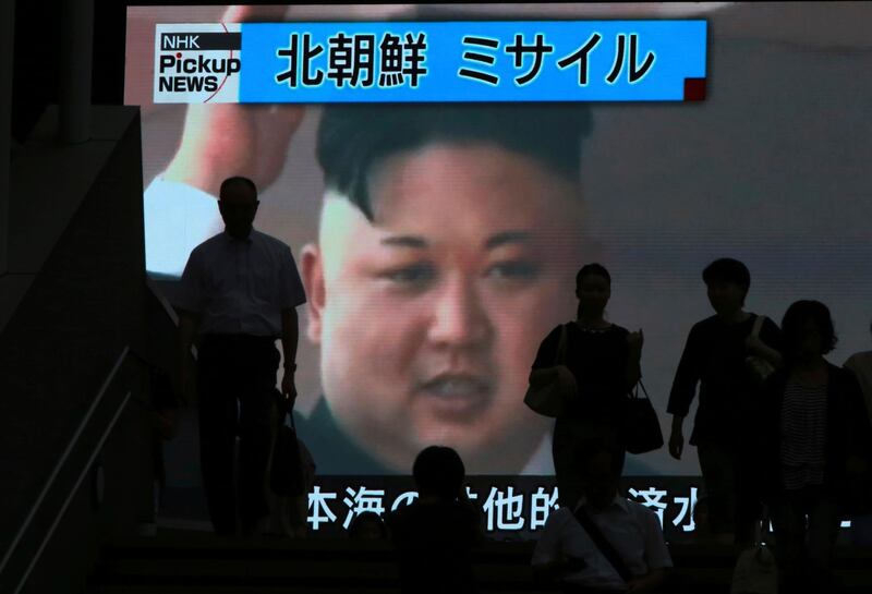 People walk past a TV news showing an image of North Korean leader Kim Jong Un while reporting North Korea's missile test which landed in the waters of Japan's economic zone (EEZ) in Tokyo Tuesday, July 4, 2017. North Korea claimed to have tested its first intercontinental ballistic missile in a launch Tuesday, a potential game-changing development in its push to militarily challenge Washington — but a declaration that conflicts with earlier South Korean and U.S. assessments that it had an intermediate range.  (AP Photo/Eugene Hoshiko)